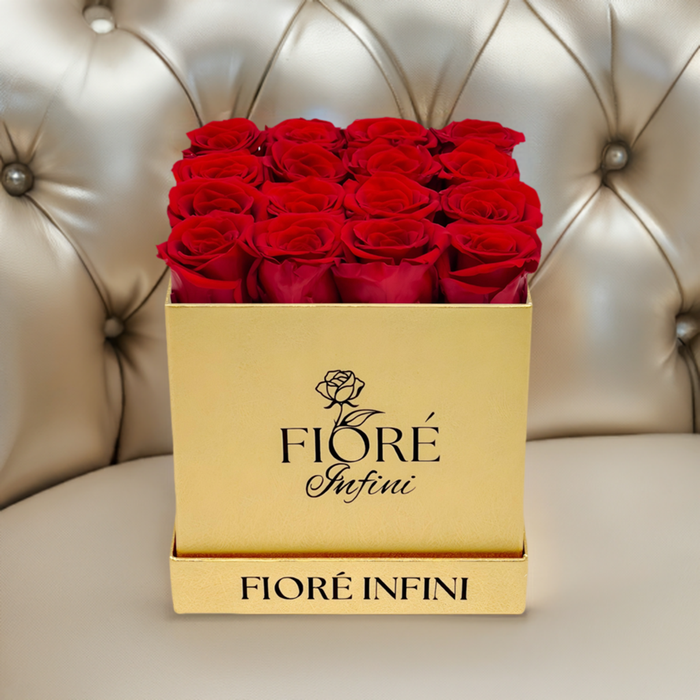 red roses in square gold box on a luxury sofa