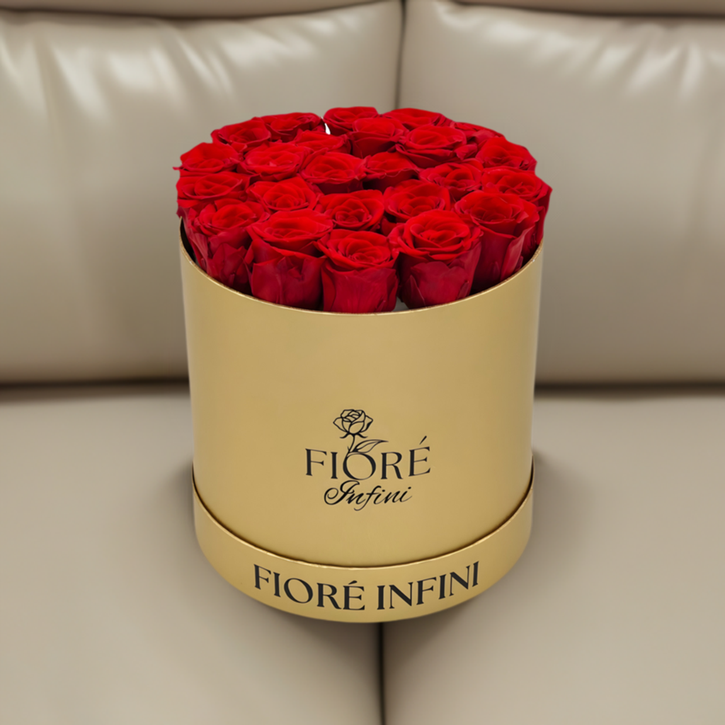 24 red roses in a gold box on a sofa