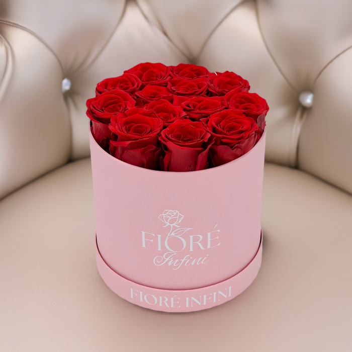 red roses in a round pink box on a luxury sofa