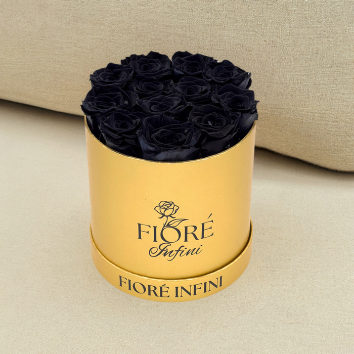 black roses in gold box in a beige sofa