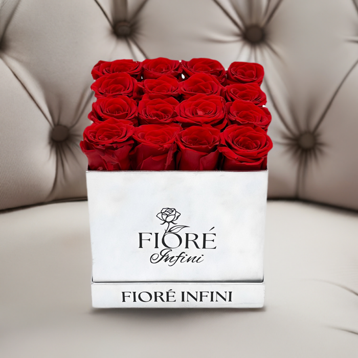 Red Forever Roses In a Silver Square Box on a luxury sofa