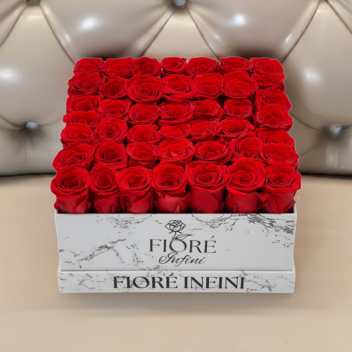 Red Preserved Roses In A Large Square Marble Box on a luxury sofa