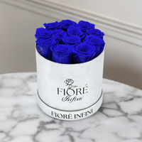 12 blue roses in silver round box on marble table