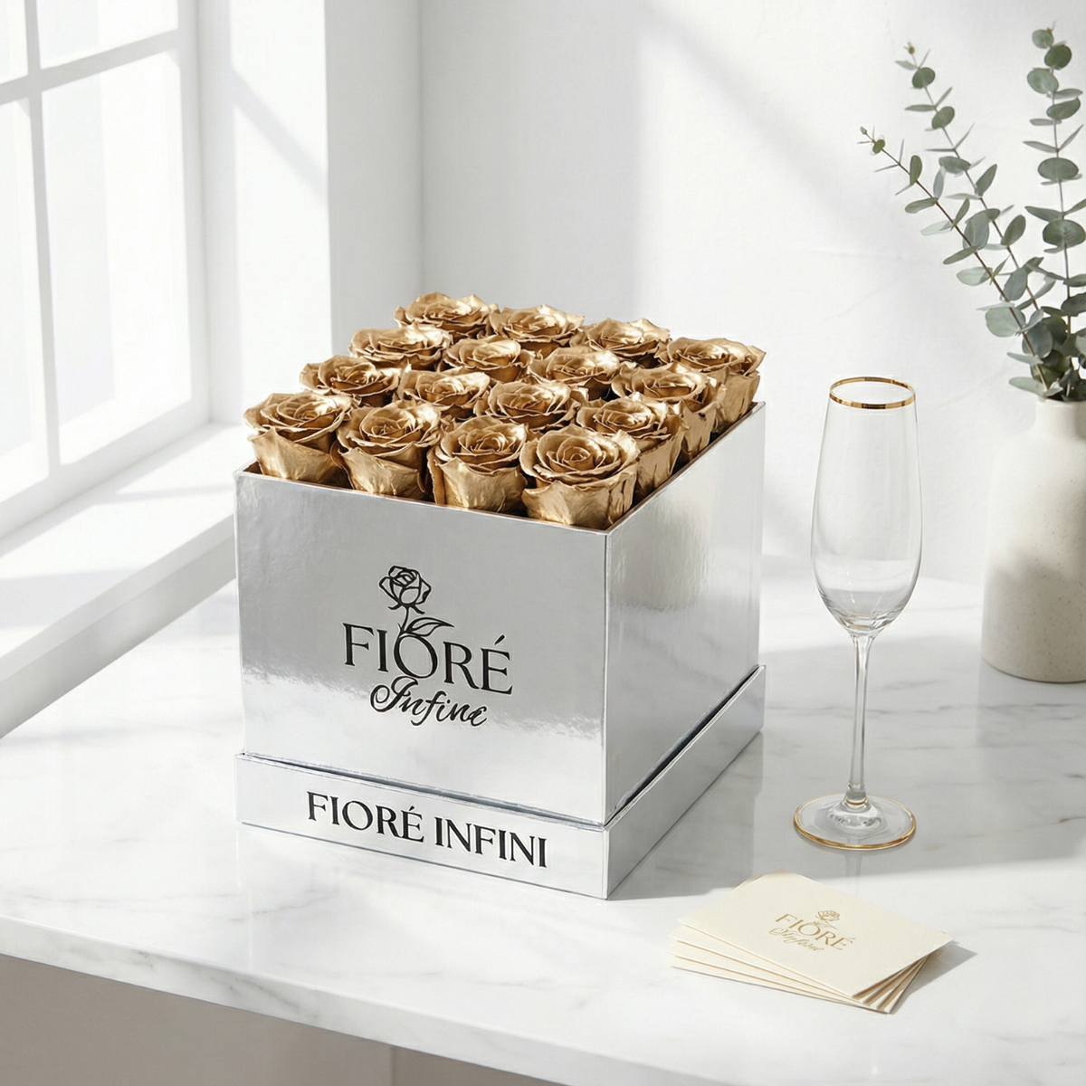 gold roses in silver box placed on a marble table