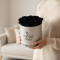 lady holding black roses in a silver box